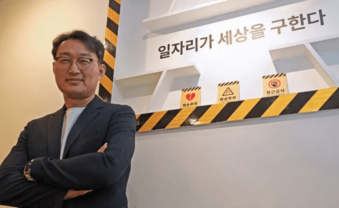 일자리가 세상을 구한다는 글귀 앞에서 팔짱을 낀 남성 직장인의 모습