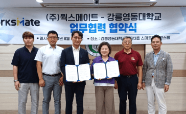 강릉영동대학교와 웍스메이트가 일자리 협약서를 들고 함께 서 있는 MOU 체결식 현장