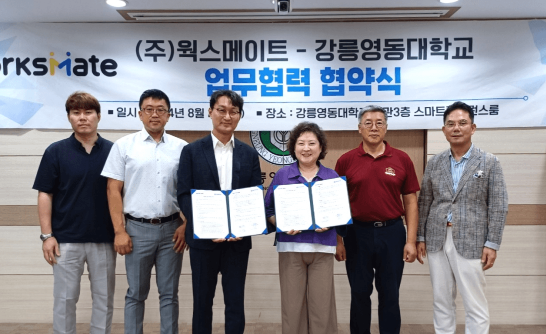 강릉영동대학교와 웍스메이트가 일자리 협약서를 들고 함께 서 있는 MOU 체결식 현장