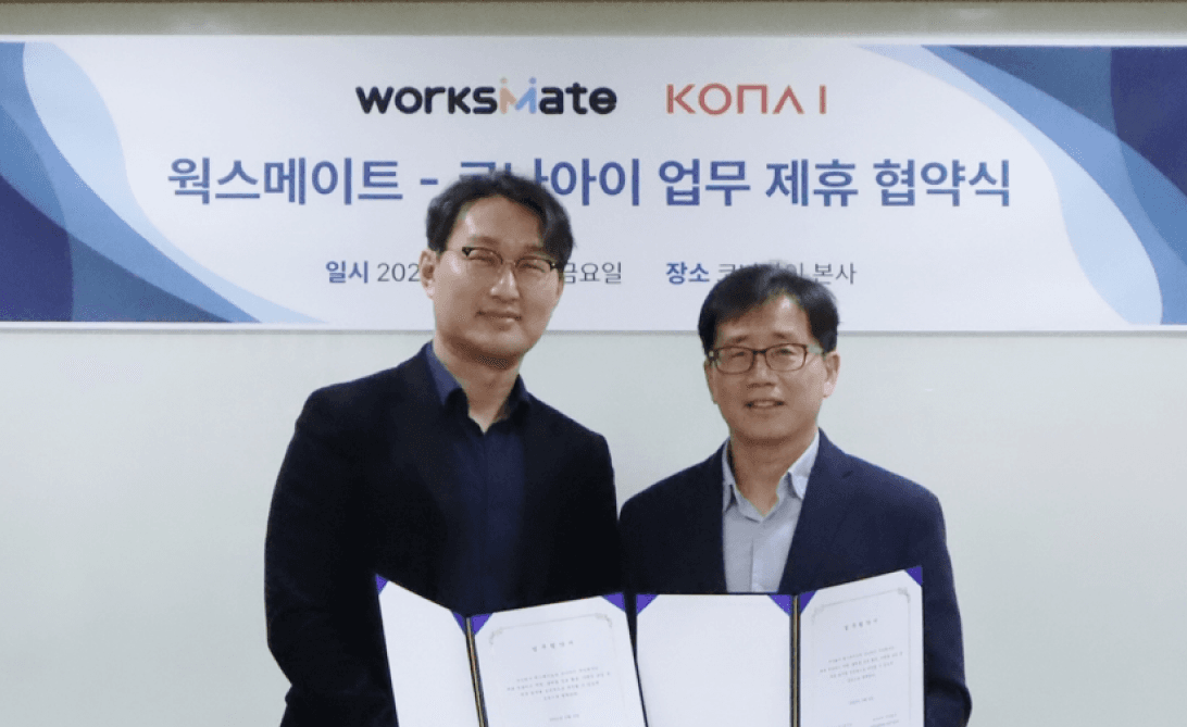 코나아이와 웍스메이트 관계자 두 명이 업무제휴 협약서를 들고 있는 모습